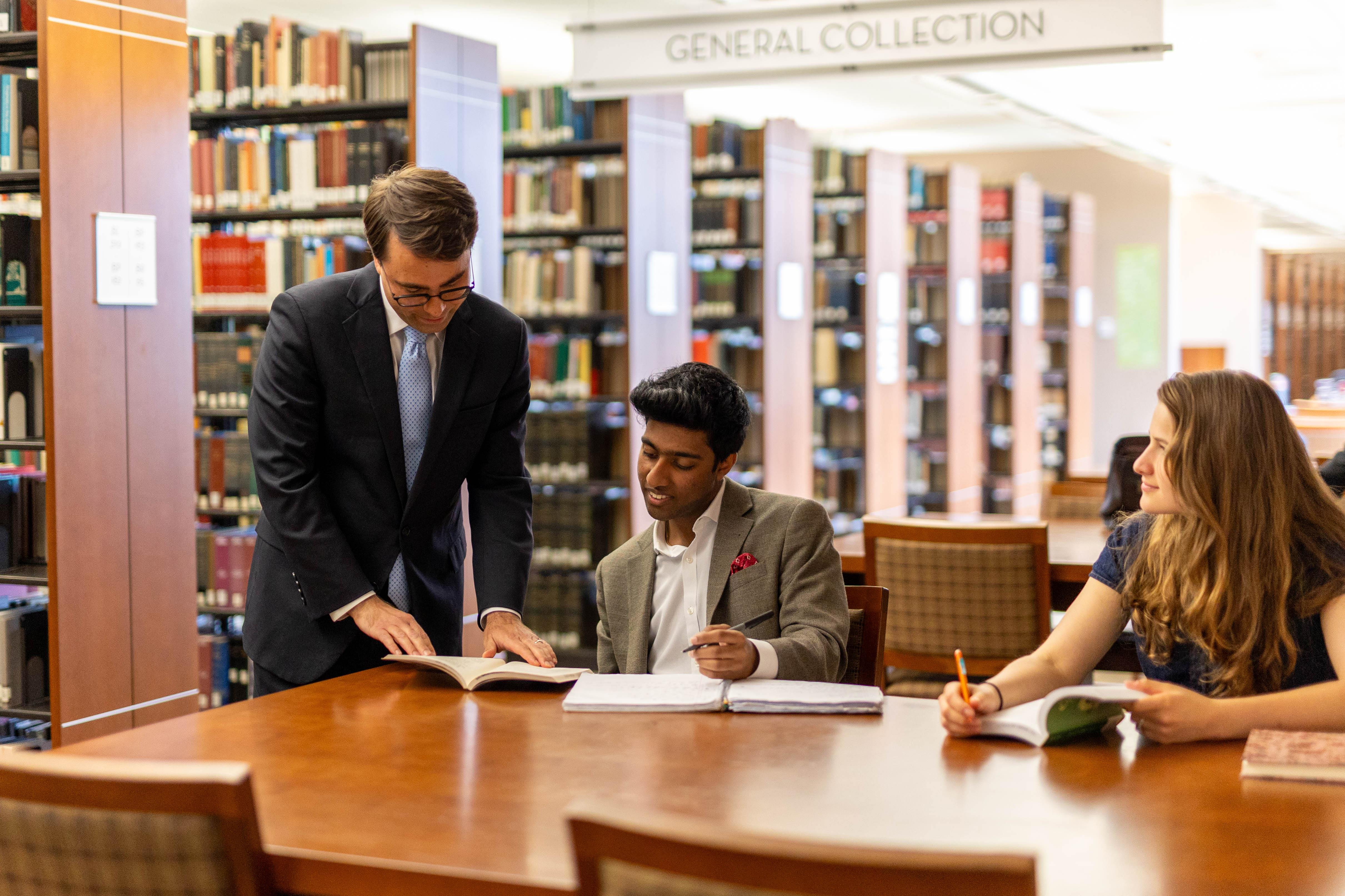 Dean Breidenbach working one-on-one with Honors students in the library